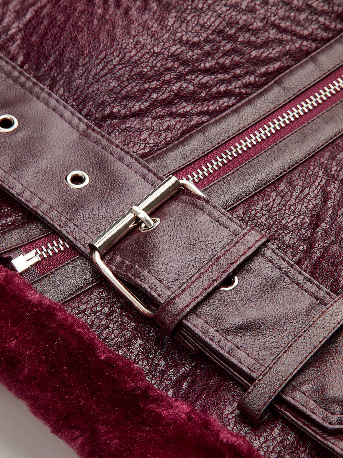 Gilberte Burgundy biker jacket, close-up of the hem belt and prong buckle