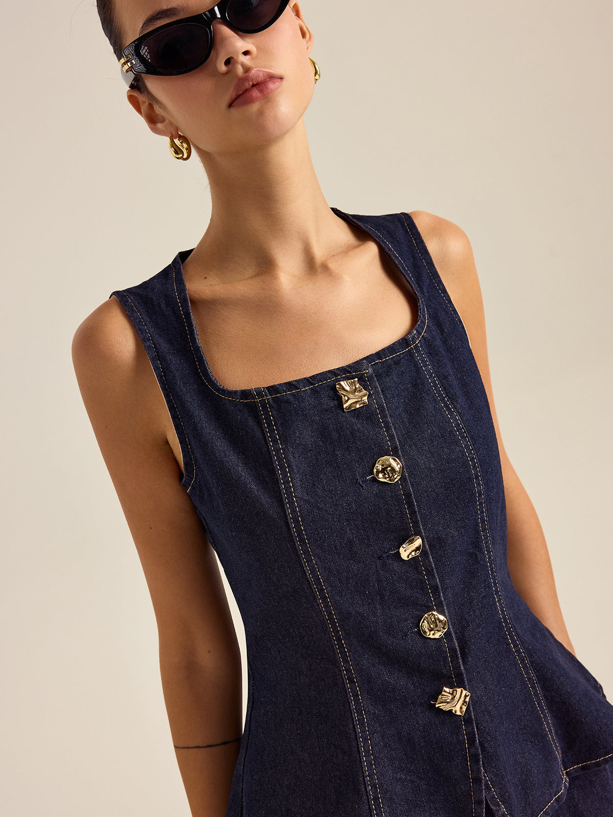 Mahaut indigo denim peplum top, close-up of the hammered gold-tone buttons
