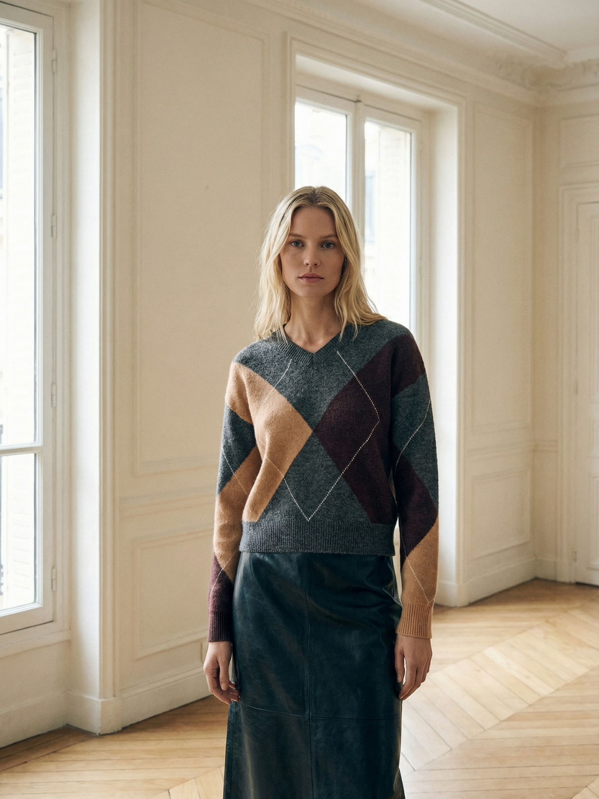 Melisande charcoal grey argyle sweater worn with a leather midi skirt, full-length view