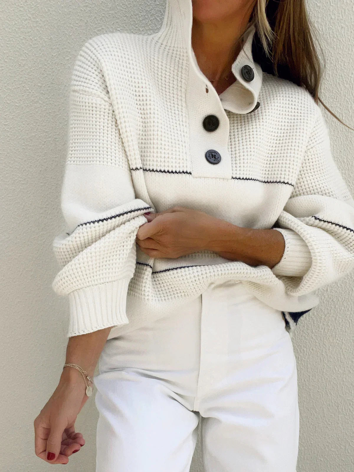 Mireille cream sweater with the collar standing and the placket buttoned
