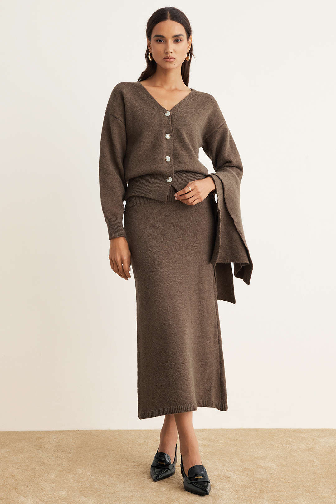 Woman wearing a brown V-neck knit cardigan with a matching knit midi skirt