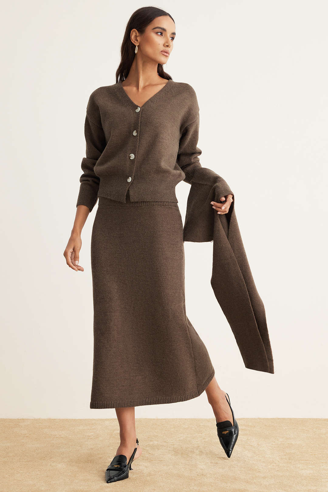 Side view of the Naelle brown V-neck cardigan and knit midi skirt