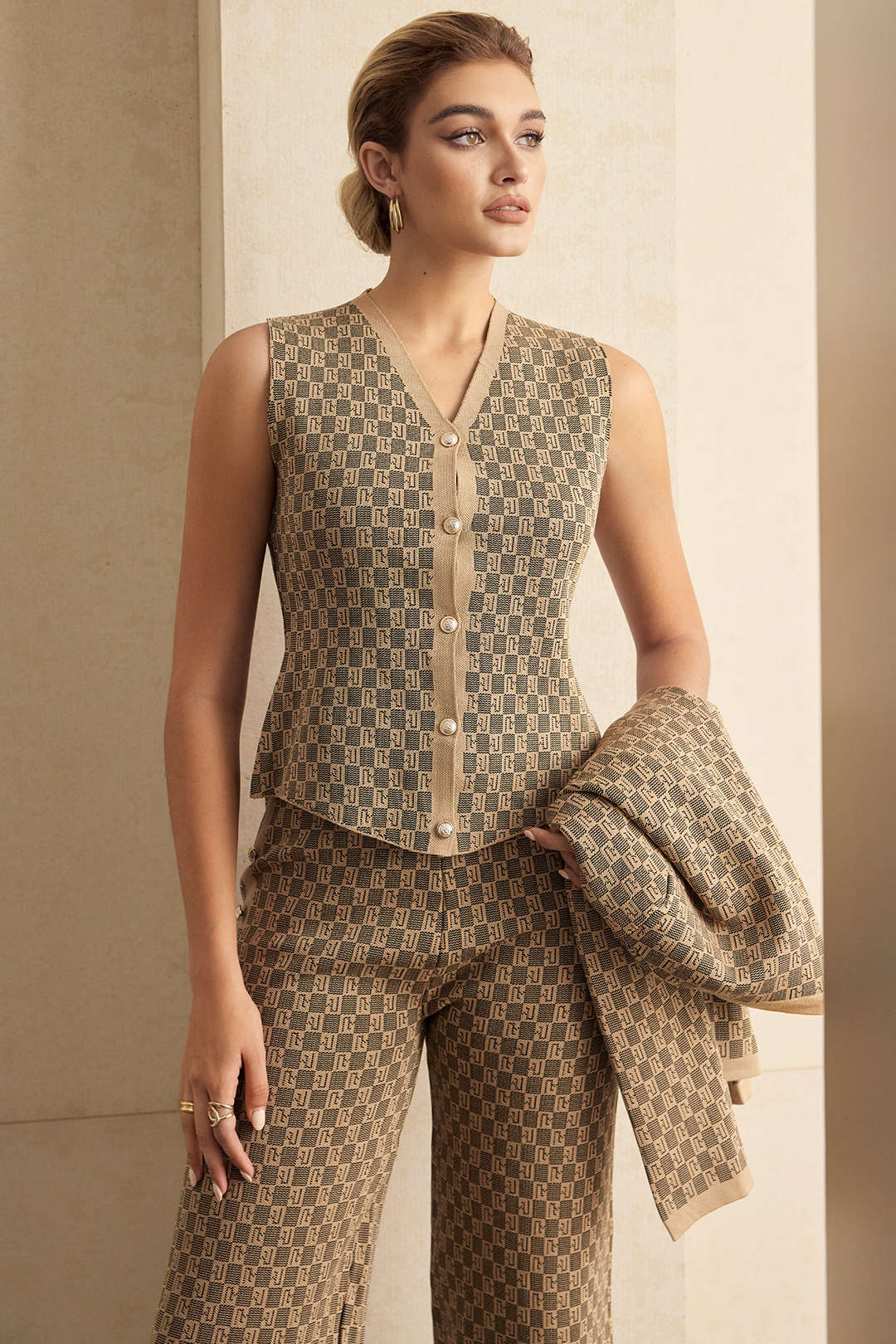 Beige jacquard waistcoat and trousers with the cardigan carried over the arm