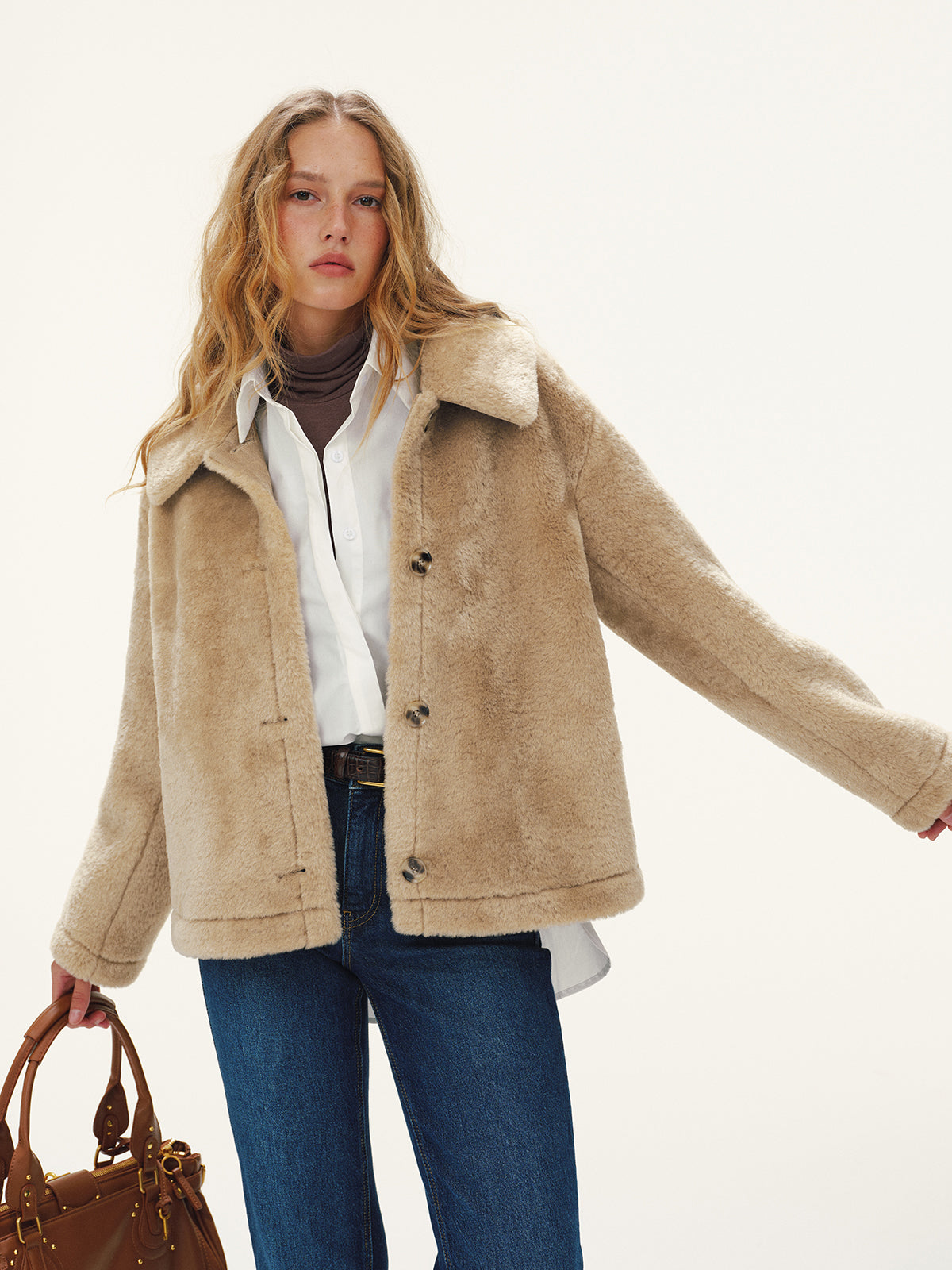 Beige plush textured jacket worn open over a white shirt and jeans, front view