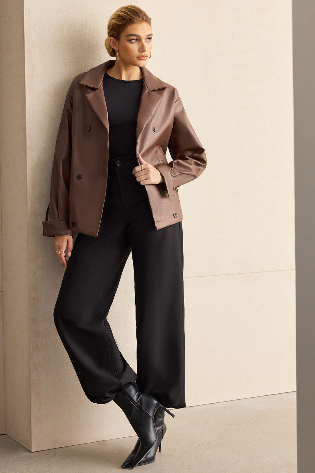 Brown double-breasted jacket worn open over black trousers, full-length front view