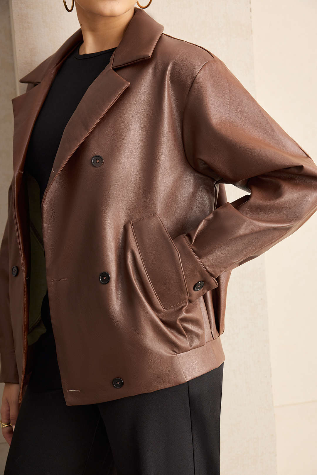 Close view of the wide lapels and double-breasted buttons on a brown jacket